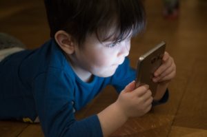 dziecko patrzy na ekran smartfona